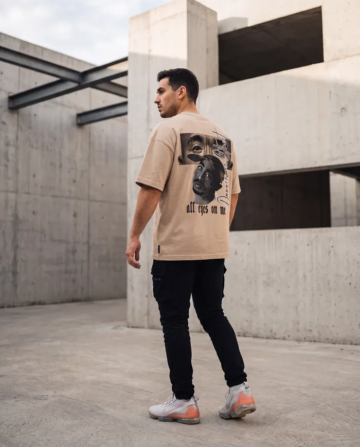 Oversized graphic tee with back print against a concrete wall