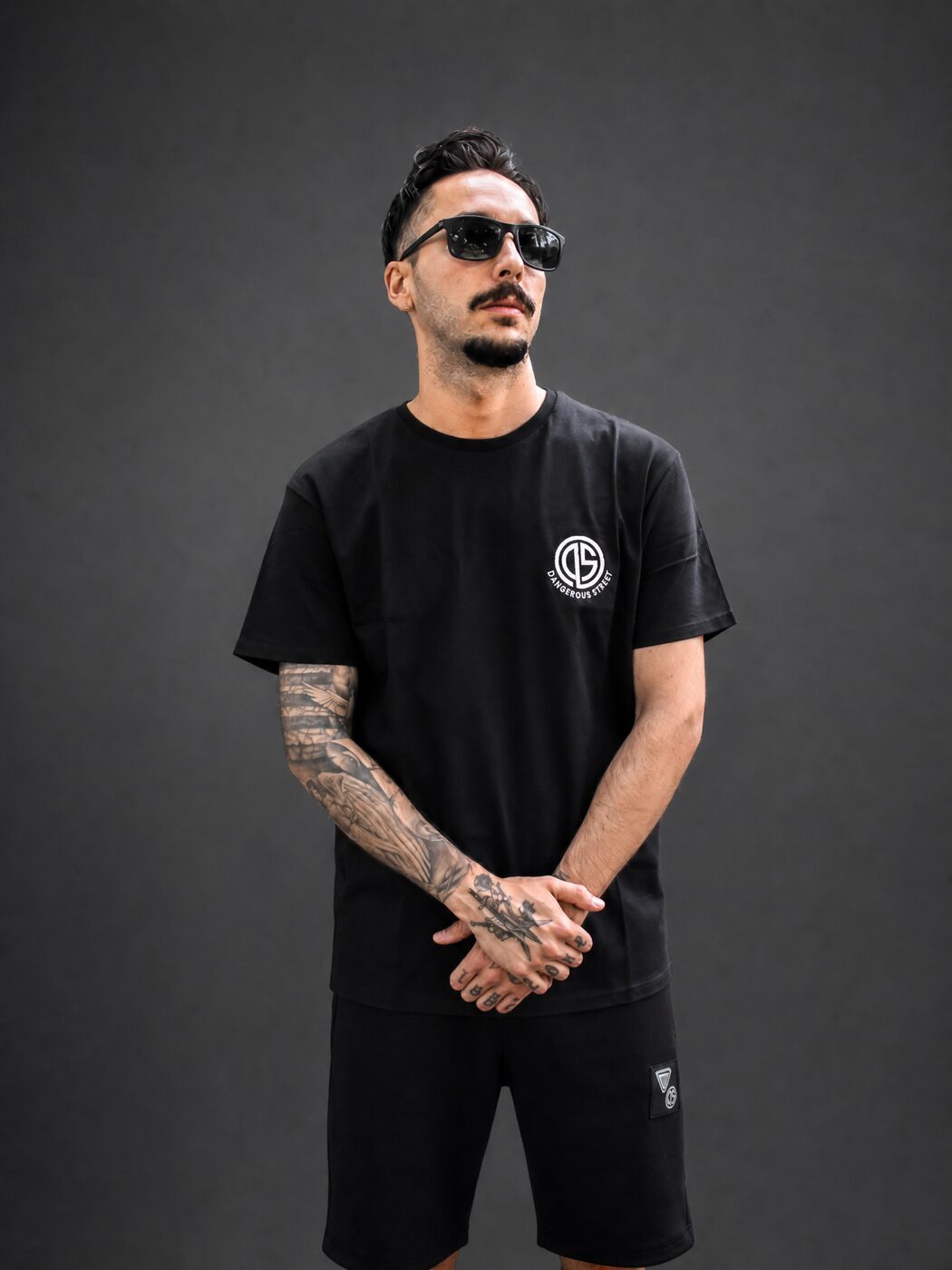 Schwarzes T-Shirt aus schwerer Baumwolle mit kleinem Logo-Print am Model, Studioaufnahme